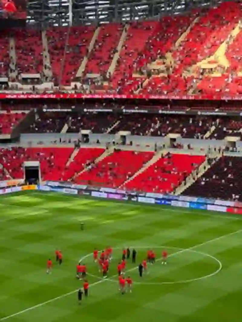 Pertandingan sepak bola yang meriah di stadion Rabat dengan tim-tim bersiap di hari yang cerah.